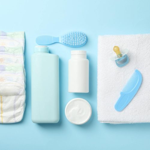 Flat lay with baby hygiene accessories on blue background
